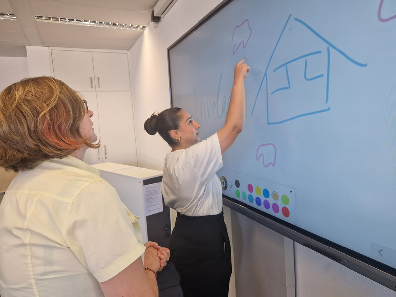 Sabine Beck, Bereichsleiterin von involas, erklärt der Schülerpraktikantin Fatma Caca am Whiteboard die Organisationsstruktur des Instituts.